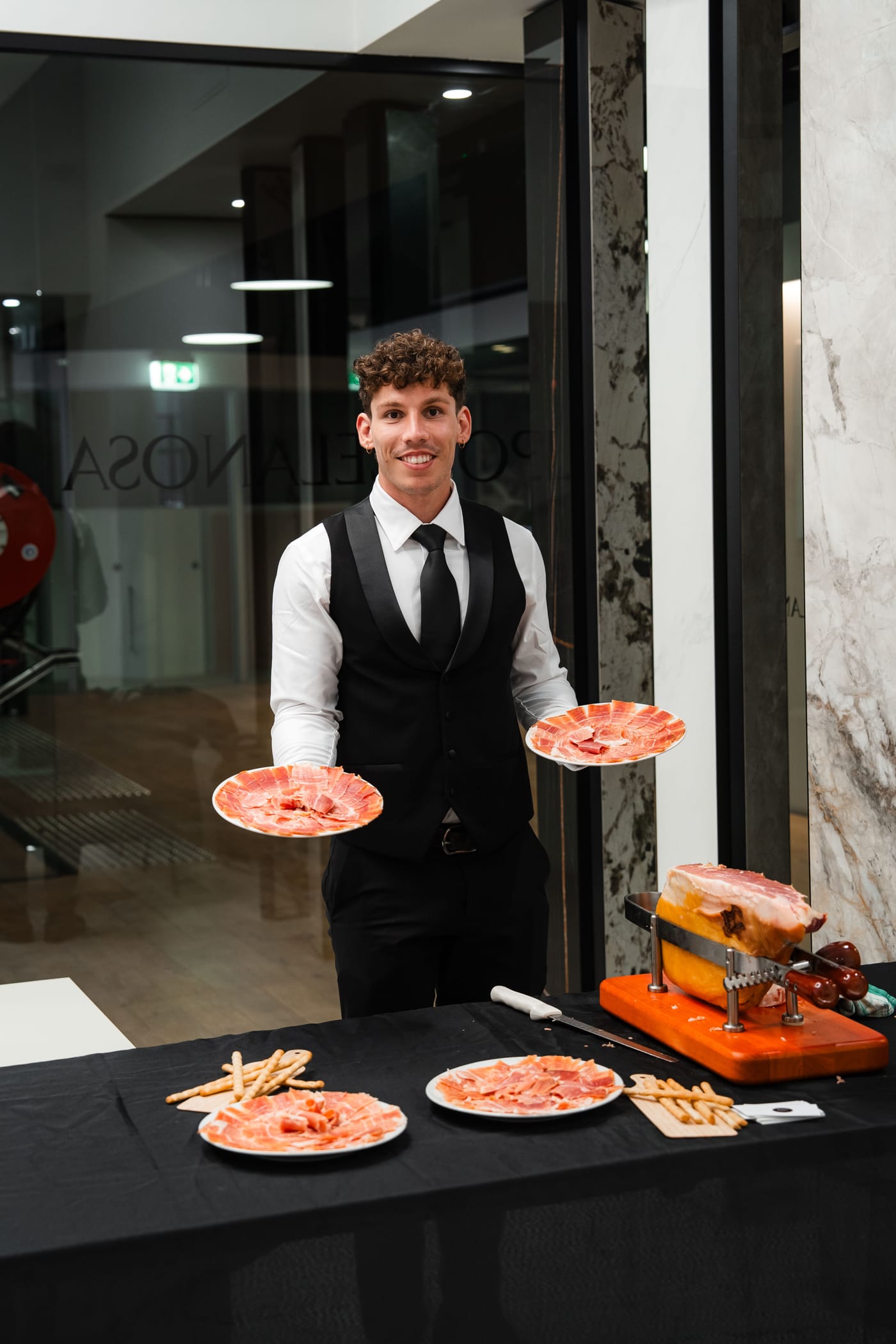 Iberico Sydney waiter presenting plates of freshly carved jamón to guests